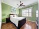 Bedroom with hardwood floors, neutral bedding, green walls, and a window with shutters at 4334 Tolkien St, Orlando, FL 32828