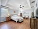 Spacious main bedroom with wood floors, tray ceiling, and comfortable seating area by the windows at 4334 Tolkien St, Orlando, FL 32828
