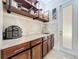 This pantry features granite countertops, dark wood cabinets, and ample storage space with shelving at 4334 Tolkien St, Orlando, FL 32828