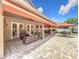 Expansive patio with outdoor seating, kitchen, and vibrant landscaping under orange awnings at 4334 Tolkien St, Orlando, FL 32828