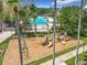 Playground with climbing structure, swings and slides, with views of a pool and sports court in background at 4334 Tolkien St, Orlando, FL 32828
