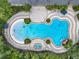 Aerial view of a resort-style pool with a beach entry, a spa, lush landscaping, and waterfall features at 4334 Tolkien St, Orlando, FL 32828