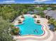 Aerial view of a resort-style pool with a waterfall, spa, lounge chairs, and lush tropical landscaping at 4334 Tolkien St, Orlando, FL 32828