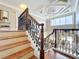 Elegant staircase featuring decorative iron railings, marble steps, and a tray ceiling at 4334 Tolkien St, Orlando, FL 32828
