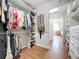 Bright and spacious walk-in closet with built-in shelving and organization, complemented by hardwood floors at 4334 Tolkien St, Orlando, FL 32828