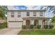 Two-story home with a charming arched porch, attached garage, manicured lawn and mature landscaping at 4531 Se 30Th St, Ocala, FL 34480