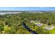 Aerial view showing a lake and homes surrounded by lush, mature trees and landscaping with water access at 5531 Marys Villa Rd, Groveland, FL 34736