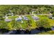 Aerial view of multiple houses with landscaping and water access near roads and wooded area at 5531 Marys Villa Rd, Groveland, FL 34736