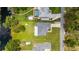 Aerial view of a house with a large backyard, trees, and a driveway, near a body of water at 5531 Marys Villa Rd, Groveland, FL 34736