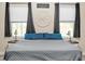 Cozy bedroom features a comfortable bed and plenty of natural light from the windows at 5531 Marys Villa Rd, Groveland, FL 34736