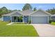 Charming, single-story home with a manicured lawn, attached garage, and a welcoming front porch at 5531 Marys Villa Rd, Groveland, FL 34736