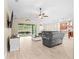 Open-concept living space featuring a large gray sectional, kitchen, dining area, and access to an outdoor patio at 5531 Marys Villa Rd, Groveland, FL 34736
