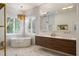 Bright bathroom with a freestanding tub, double vanity, and marble flooring at 6047 Blakeford Dr, Windermere, FL 34786