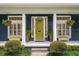 Inviting front porch featuring a bright green door, hanging plants, and stylish seating at 6047 Blakeford Dr, Windermere, FL 34786