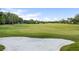 Picturesque view of a lush green golf course from the backyard with sand trap at 6047 Blakeford Dr, Windermere, FL 34786