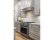 Modern kitchen featuring stainless steel appliances, stone backsplash, and custom cabinets at 6047 Blakeford Dr, Windermere, FL 34786