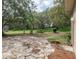 A backyard featuring a stone patio and surrounded by lush landscaping and mature trees at 636 Cheviot Ct, Apopka, FL 32712