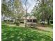 Home exterior view of the backyard with a screened lanai and mature trees at 636 Cheviot Ct, Apopka, FL 32712