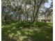 A backyard with well-manicured lawn surrounded by trees and dense shrubs at 636 Cheviot Ct, Apopka, FL 32712