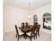 Elegant dining room with a classic chandelier and views of the outdoors through arched windows at 636 Cheviot Ct, Apopka, FL 32712