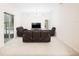 Spacious living room with plush carpet, fan, and comfortable dark leather furniture at 636 Cheviot Ct, Apopka, FL 32712