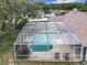 Aerial view of a screened-in pool surrounded by greenery, nestled within a residential neighborhood at 6970 Knightswood Dr, Orlando, FL 32818