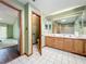 Bathroom with double sink vanity, tiled floor, and separate toilet room, and view to bedroom at 6970 Knightswood Dr, Orlando, FL 32818