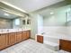 Bathroom features a large soaking tub, double sinks, and tiled floors and walls at 6970 Knightswood Dr, Orlando, FL 32818