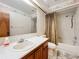 Bathroom featuring single sink vanity and shower-over-tub combination with brown curtain at 6970 Knightswood Dr, Orlando, FL 32818