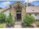Welcoming front entrance with a covered porch, brick columns, and lush landscaping creating curb appeal at 6970 Knightswood Dr, Orlando, FL 32818