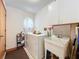 Functional laundry room featuring a washer, dryer, utility sink, and organized shelving for storage at 6970 Knightswood Dr, Orlando, FL 32818