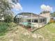 Beautiful pool with a screened enclosure, surrounded by lush landscaping and greenery at 6970 Knightswood Dr, Orlando, FL 32818