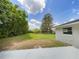 Spacious backyard with green grass and mature trees at 7040 Hennepin Blvd, Orlando, FL 32818