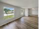 Open-concept living area showcasing luxury vinyl floors and bright natural light from large windows at 7040 Hennepin Blvd, Orlando, FL 32818