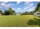 Spacious backyard with a well-maintained lawn, lush greenery, and a small storage shed at 7102 Easter St, Winter Park, FL 32792