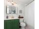 Charming bathroom with green vanity, decorative wallpaper, and a shower with a white curtain at 7102 Easter St, Winter Park, FL 32792