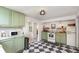 Charming kitchen featuring green cabinets, checkered floors, and open layout to the breakfast nook at 7102 Easter St, Winter Park, FL 32792
