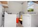 Functional laundry room with updated appliances and brick-patterned flooring for added texture and style at 7102 Easter St, Winter Park, FL 32792