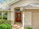 Close-up of front door with glass detailing and number above it on a home with well-kept landscaping at 748 Andover Cir, Winter Springs, FL 32708