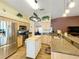 Well-lit kitchen with light wood cabinetry, stainless steel appliances, island and speckled granite countertops at 748 Andover Cir, Winter Springs, FL 32708