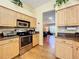Bright, efficient kitchen featuring stainless steel appliances, light wood cabinetry, and hardwood flooring at 748 Andover Cir, Winter Springs, FL 32708