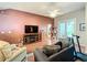 Comfortable living room with a large TV, plush seating, ceiling fan and glass doors to the patio at 748 Andover Cir, Winter Springs, FL 32708