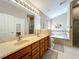 Bright main bathroom featuring double sinks, a soaking tub with tile surround, and a glass shower at 748 Andover Cir, Winter Springs, FL 32708