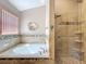 Bright main bathroom featuring a soaking tub with tile surround, and a glass shower at 748 Andover Cir, Winter Springs, FL 32708
