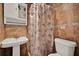 Updated bathroom with flamingo shower curtain, pedestal sink, and ceramic tile walls at 7807 Pine Hawk Ln, Orlando, FL 32822