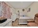 Bedroom with a dresser, chair, and patterned curtains allowing natural light at 7807 Pine Hawk Ln, Orlando, FL 32822