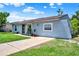 Single-story home with a well-maintained lawn, concrete driveway, and lush landscaping at 7807 Pine Hawk Ln, Orlando, FL 32822
