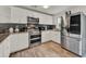 Modern kitchen featuring stainless steel appliances, granite countertops, and white cabinets at 7807 Pine Hawk Ln, Orlando, FL 32822