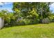 Fenced backyard features a mix of grass, foliage, and trees at 8116 Parrot Dr, Orlando, FL 32825