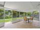 Covered patio with tile floor, screens, and view of landscaped backyard at 8116 Parrot Dr, Orlando, FL 32825